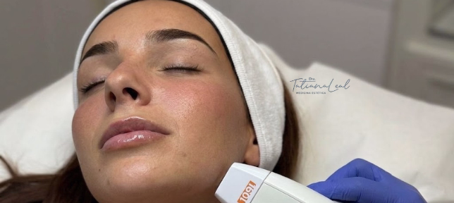 Paciente con banda en el cabello recibiendo un tratamiento facial con aparato